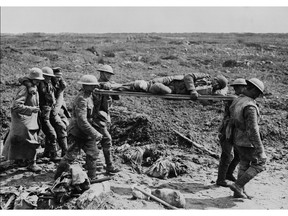FILE-- Stretcher bearers and German prisoners bring in wounded soldiers on Vimy Ridge in France in this April 1917 photo. (CP ARCHIVE PHOTO) 1999 (National Archives of Canada)