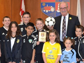 Members of the LaSalle Stompers Soccer Club surround LaSalle Mayor Ken Antaya on Tuesday, April 12, 2016. The club was recognized by LaSalle Council Tuesday night for their Ontario Soccer Association Club Excellence Gold award.