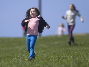 Avery Carbonaro, 7, is all smiles as she runs down the hill at Malden Park, Sunday, April 24, where hundreds gathered to celebrate Earth Day.