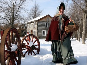 Essex, ON. December 20/2005 - Dressed in early twentieth century attire, Kathleen Storey carries a basket of food from the Holden log cabin at the Southwestern Ontario Heritage Museum on the Arner Townline, Wednesday.  Extremely large for its era, the Holden log cabin was built in 1864 and is one of about a dozen original homes and structures located at the museum.  Another example is the homestead of Laona and Jack Miner, built in 1889 and the Olinda general store from 1840.  The Windsor Star - Nick Brancaccio