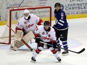 Leamington Flyers J.P. Grineau and goaltender Tyler Wall defend London Nationals Kevin Madden during first period Greater Ontario Junior Hockey League playoff action in Leamington, Ontario on March 31, 2016.