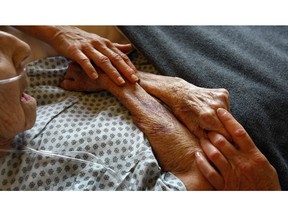 In this file photo, Hospice volunteers caress the hands of terminally ill patient Annabelle Martin, 92, as her health quickly declined at the Hospice of Saint John on September 1, 2009 in Lakewood, Colorado. The non-profit hospice, which serves on average 200 people at a time, is the second oldest hospice in the United States. The hospice accepts patients regardless of their ability to pay, although most are covered by Medicare or Medicaid. End of life care has become a contentious issue in the current national debate on health care reform.