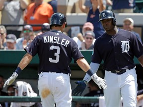 After hitting a home run in the fifth inning, Detroit Tigers' Ian Kinsler is congratulated by teammate Justin Upton as crosses home plate in a spring training baseball game, Thursday, March 31, 2016, in Lakeland, Fla.