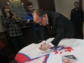 Windsor Mayor Drew Dilkens signs a jumbo jersey on March 24, 2016 that will be part of the city's bid to host the 2017 Memorial Cup.