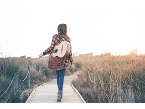 Walking with guitar outdoors. Photo by fotolia.com.