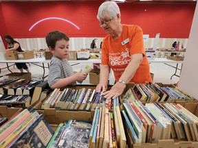It was another busy weekend for the Windsor Star Raise-A-Reader book sale at the Devonshire Mall on Saturday, April 16, 2016. Tayven Leblanc gets some help from volunteer Donna Cowie during the sale.