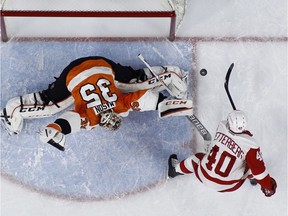 Philadelphia Flyers' Steve Mason, left, blocks a shot by Detroit Red Wings' Henrik Zetterberg during an NHL hockey game on March 15, 2016, in Philadelphia.