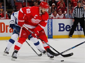 Henrik Zetterberg #40 of the Detroit Red Wings tries to control the puck in front of Alex Killorn #17 of the Tampa Bay Lightning during the  Stanley Cup playoffs at Joe Louis Arena on April 19, 2016 in Detroit, Michigan.