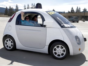 Passengers wave from a new Google self-driving prototype car during a demonstration on May 13, 2015 at Google's campus in Mountain View, Calif.