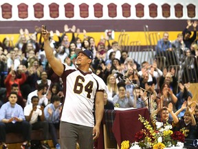 Tyrone Crawford from the National Football League's Dallas Cowboys records a message for social media while speaking to students and staff at Catholic Central Catholic High School on April 13, 2016 in Windsor, Ont.