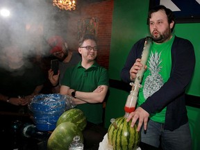 Jon Peladeau (right) takes a hit off a watermelon bong at downtown Windsor's Higher Limits on April 20, 2016. Higher Limits co-owner Jon Liedtke (left) looks on.