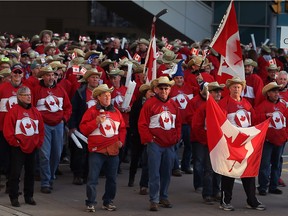 Windsor, Ontario. April 03, 2016 -- Greg Welton holds the Canadian flag and Wayne MacLeish holds Team Canada sign leading a huge team during Opening ceremonies of CARHA World Cup at Caesars Windsor for parade and street party in downtown Windsor Sunday April 03, 2016.  Welton and MacLeish are members of Lindsay Pontiac Pasttimers of Lindsay, Ontario. (NICK BRANCACCIO/Windsor Star)