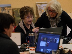 June Gauntley, 74, centre, spent her birthday weekend attending a digital scrapbooking retreat held by Forever Services at Holiday Inn Select on Huron Church Sunday April 3, 2016. Friend Donna Lee Kerr, right, of Ancaster assists with photo selection.