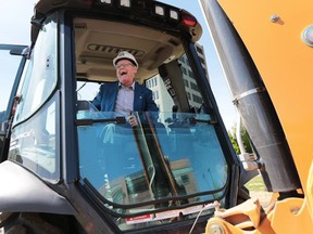 David Wilson hopped into a backhoe after making a $1M donation to the University of Windsor on Friday, May 20, 2016. (Dan Janisse/Windsor Star)