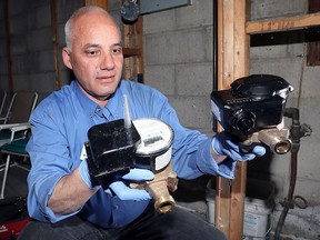 Plumber Surish Farias compares the old water meter, left, with a new integrated water meter in a basement on Academy Drive in South Windsor, Friday May 20, 2016.