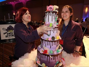Gabrielle Denonville, left, and Danielle Beach of Sweet Revenge Bake Shop with a massive, custom cake at Battle of the Hors D'oeuvres at Caesars Windsor Augustus Ballroom Thursday May 26, 2016.  The annual event is hosted by Big Brothers Big Sisters of Windsor Essex Foundation.
