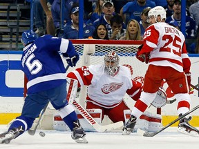 Jason Garrison #5 of the Tampa Bay Lightning shoots against Petr Mrazek #34 of the Detroit Red Wings as Mike Green #25 looks on during the first period in Game Five of the Eastern Conference First Round during the 2016 NHL Stanley Cup Playoffs at Amalie Arena on April 21, 2016 in Tampa, Florida.