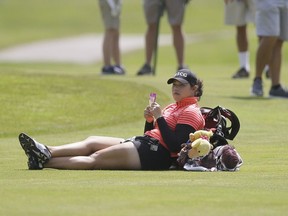 Ariya Jutanugarn, of Thailand, takes a break on the sixth fairway as play backs up during the third round of the LPGA Volvik Championship golf tournament at the Travis Pointe Country Club, Saturday, May 28, 2016, in Ann Arbor, Mich.