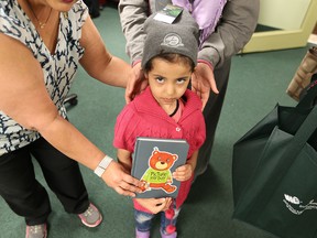 From Syrian refugee Rim Ali, age 4, holds a book that was included in a surprise backpack of goods on May 13, 2016 at the Multicultural Council in Windsor, Ont.