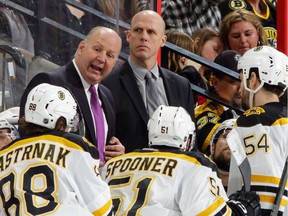 Head coach Claude Julien, left, and assistant coach Doug Houda of the Boston Bruins talk to their players during a timeout on March 10, 2015 in Ottawa.