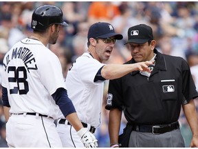 Detroit Tigers manager Brad Ausmus, center, and J.D. Martinez (28) argue with home plate umpire Alfonso Marquez during a game against the Texas Rangers Saturday, May 7, 2016, in Detroit.