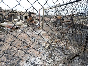 Burned out bicycles are seen behind a fence  in the Abasands neighbourhood during a media tour of the fire-damaged city of  Fort McMurray, Alberta, Canada, on  May 9, 2016.