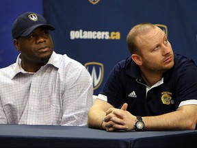 Former University of Windsor Lancers assistant football head coach Donnavan Carter sits next to head coach Joe D'Amore in this 2013 file photo.