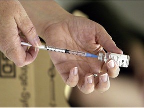 A nurse loads a syringe with flu vaccine in this Saturday, Oct. 23, 2004 photo.