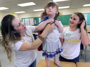 A group of Grade 7 students at the Amherstburg Public School were making superhero capes for children battling cancer on Monday, May 30, 2016. They had a visit from Happy Soul Project celebrity Pip McCallan and her mom Tara McCallan. Pip models one of the capes as her mother Tara, left, and student Rachel Jones look on.