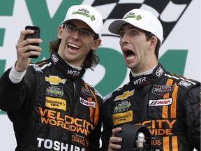 Jordan Taylor, left, and his brother Ricky Taylor take a photo of themselves in Victory Lane after they placed second in the IMSA Series Rolex 24 hour auto race at Daytona International Speedway in Daytona Beach, Fla., on Jan. 26, 2014.