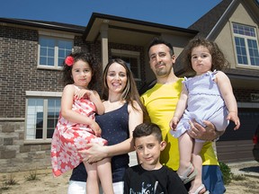 The Bakkaoui family, from left, Olivia, 3, Catherine, Isaac, 5, Kahlid, and Sofia, 1, are pictured in front of their new home in LaSalle, Monday, May 23, 2016.