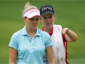 Brooke Henderson, left, and her sister Brittany, who is her caddie, line up a putt on the second hole during the third round of the Kingsmill Championship on May 21, 2016 in Williamsburg, Virginia.