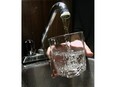 A faucet fills a glass of water.