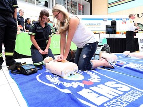 Kasia Lewczyk takes part in a CPR demonstration with St. Clair College paramedic program student Samantha Scussolin during Paramedic Services Week at Devonshire Mall on May 26, 2016.