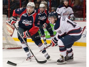 Eric Diodati (27) of the Windsor Spitfires skates against Dylan Sadowy (10) of the Saginaw Spirit on March 6, 2014 at the WFCU Centre in Windsor.