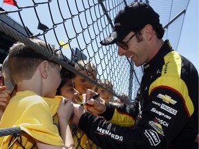 Simon Pagenaud, of France, signs autographs for students during a practice session for the Indianapolis 500 at Indianapolis Motor Speedway in Indianapolis on May 19, 2016.