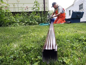 Keith Devlin, of the city's field engineering department, disconnects a downspout at a home on Josephine Avenue in this 2015 file photo.