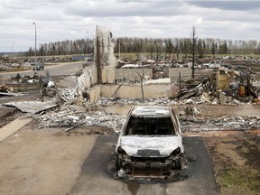 A charred vehicle and home are pictured in the Beacon Hill neighbourhood of Fort McMurray, Alberta, Canada, May 9, 2016 after wildfires forced the evacuation of the town. Fort McMurray is still 90-percent intact despite a week of damage from the wildfires devastating Canada's oil sands region, Alberta's premier said after touring the deserted city on Monday. Firefighters warned however that the tens of thousands of residents evacuated from the western oil city would not be able to return for at least two weeks.