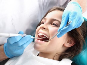 Treatment of the tooth, the dentist cleans teeth. (Fluoride). Photo by Getty Images.