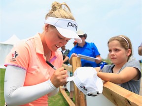 Brooke Henderson of Canada signs an autograph for a fan during the second round of the Volunteers of America Texas Shootout at Las Colinas Country Club on April 29, 2016 in Irving, Texas.