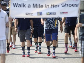 Dozens of men participate in the Walk a Mile in Her Shoes event at the Riverside Sportsmen Club, Saturday, May 28, 2016.  The event is held to educate and rally the community to prevent sexualized violence.