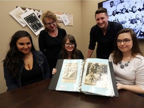 Lauren Miceli, left, Heidi Jacobs, Miriam Wright, Dave Johnston and Kayla Dettinger look through a scrapbook of Wilfred "Boomer" Harding at the University of Windsor recently. The group is researching the Chatham-area athlete who broke racial barriers.