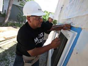 Caesars Windsor employees Randy and Laura Groulx help install windows on the latest Habitat for Humanity home in Windsor on Tuesday,