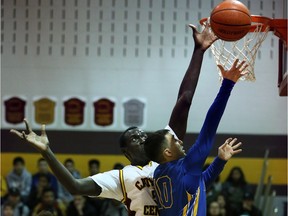 Jonathan Nicola of Catholic Central Comets blocks a shot by Ali Mansour of Kennedy Clippers in a senior boys high school basketball game at Catholic Central High School gym on Jan. 5, 2016.