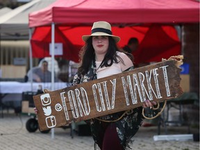 Grace Laporte, Ford City Market co-ordinator and creative developer, prepares to hang the new Ford City Market sign on the front doors at 1367 Drouillard Road May 05, 2016.