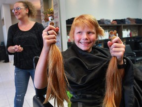 Lincoln Mason, 10, has five ponytails of his abundant red hair cut by stylist Brittany Lyons at Fringe Theory Salon June 7, 2016.