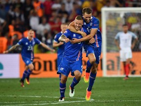(LtoR) Iceland's defender Ragnar Sigurdsson and Iceland's defender Kari Arnason celebrate their team's win after the Euro 2016 round of 16 football match between England and Iceland at the Allianz Riviera stadium in Nice on June 27, 2016.  
Iceland won the match 1-2. / AFP PHOTO / BERTRAND LANGLOISBERTRAND LANGLOIS/AFP/Getty Images