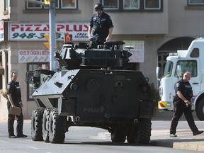 Windsor police officers are shown with the department's tactical rescue vehicle on Pillette Rd. on Wednesday, June 1, 2016 in Windsor, ON. Police set up a multi-block perimeter surrounding a residence on Pillette Rd. where a gunman was eventually arrested without incident. (DAN JANISSE/The Windsor Star)