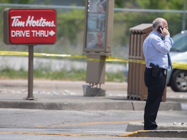 A Windsor police detective investigates outside the Tim Hortons at Wyandotte St. East and Walker Rd. after a shooting, Wednesday, June 22, 2016. The assailant is still at large. (DAX MELMER/The Windsor Star)