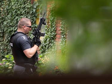 A Windsor police officer holds a tactical assault rifle outside a home on Monmouth Rd. after a shooting outside the Tim Hortons at Wyandotte St. East and Walker Rd., Wednesday, June 22, 2016.  The assailant is still at large.  The location on Monmouth Rd. was a false lead.